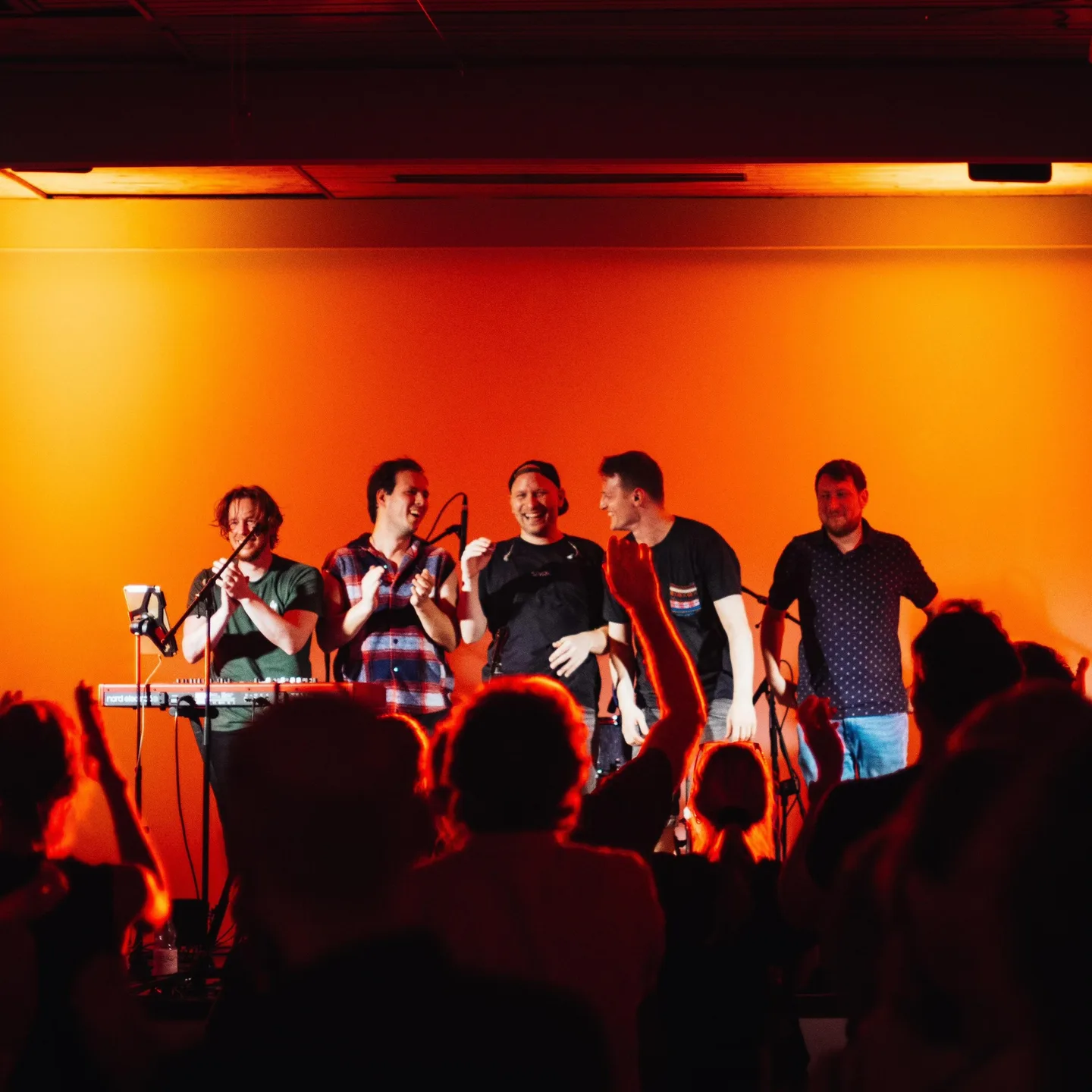 minor kings beim Applaus im Kulturgasthaus vor orange beleuchteter Bühne