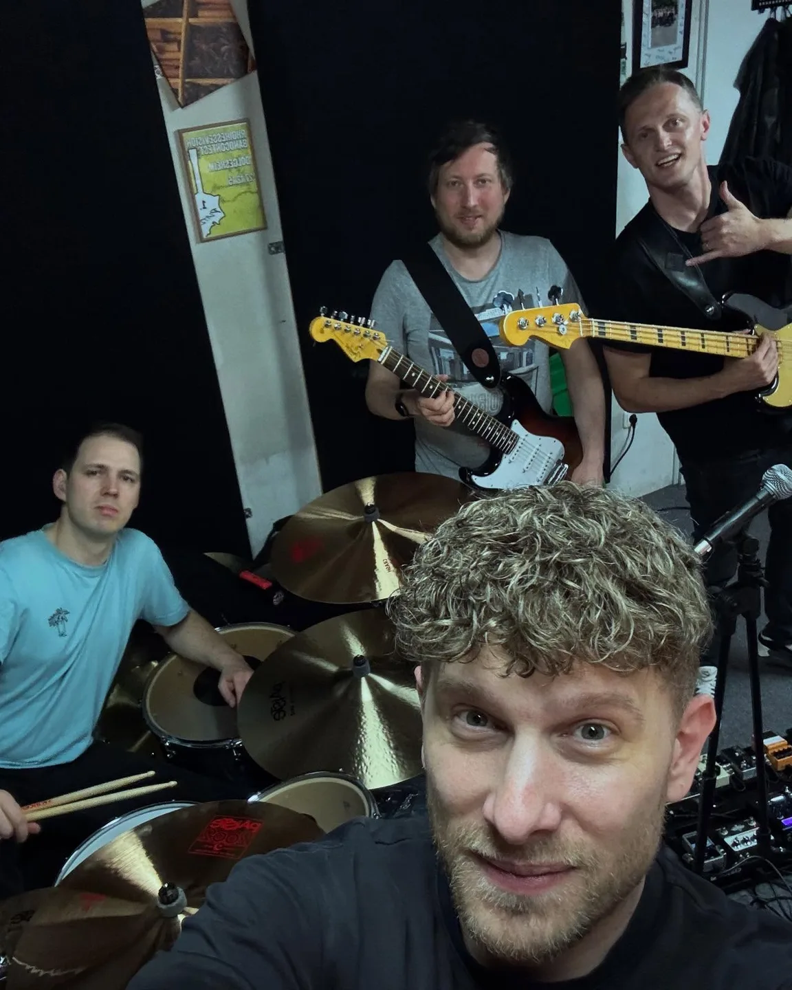 Band-Selfie im Proberaum mit Gitarren und Schlagzeug